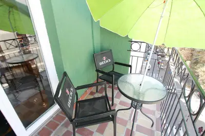 a balcony with a table and chairs and an umbrella at Njegoševa Presidential Suite Vračar in Belgrade
