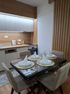 a dining room table with chairs and a kitchen at Gala Lux Lazarevac in Lazarevac