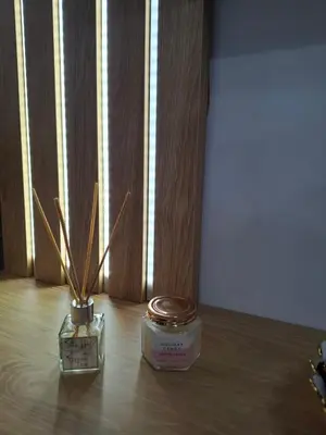 two candles sitting on a wooden table with a window at Gala Lux Lazarevac in Lazarevac
