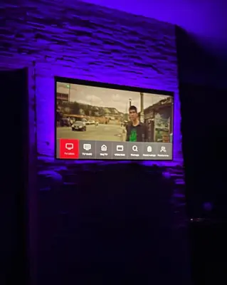 a tv on a brick wall with purple lights at Leyla Lux in Bele Vode