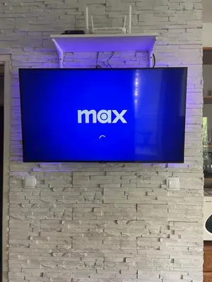 a tv hanging on a brick wall at Leyla Lux in Bele Vode