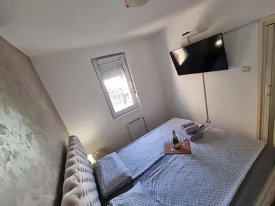 a bedroom with a bed with a television on the wall at Leyla Lux in Bele Vode