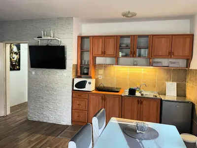 a kitchen with wooden cabinets and a table with chairs at Leyla Lux in Bele Vode