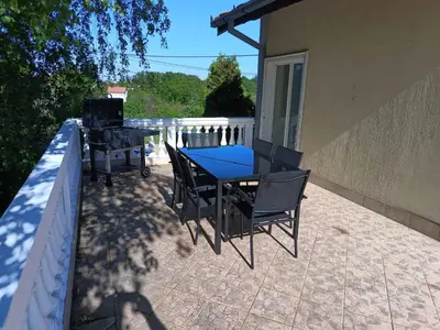 a patio with a table and chairs and a grill at Cozy Place in Pavi°evac
