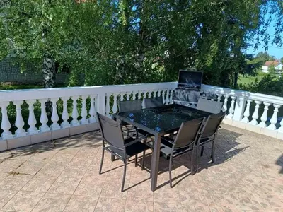 a table and chairs on a patio with a fence at Cozy Place in Pavi°evac