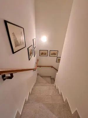 a hallway with stairs with pictures on the walls at Plavi zec apartman Zemun in Belgrade