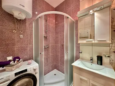 a bathroom with a washing machine and a sink at Plavi zec apartman Zemun in Belgrade
