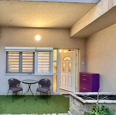 a patio with two chairs and a table in front of a house at Plavi zec apartman Zemun in Belgrade