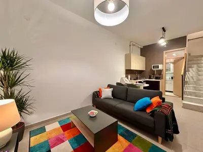 a living room with a couch and a colorful rug at Plavi zec apartman Zemun in Belgrade