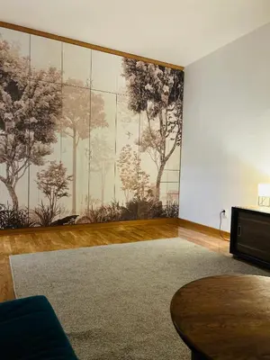 a living room with a large mural of trees on the wall at Surya in Belgrade