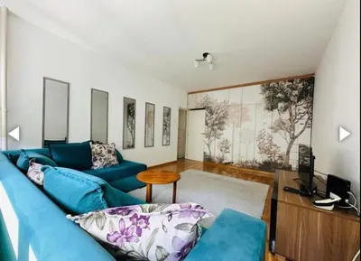 a living room with a blue couch and a table at Surya in Belgrade
