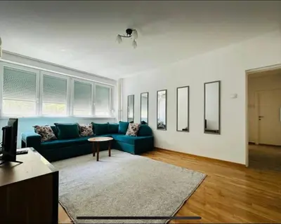 a living room with a blue couch and a table at Surya in Belgrade