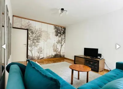 a living room with a blue couch and a table at Surya in Belgrade