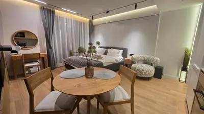 a living room with a table and a room with a bed at Genex SPA in Belgrade