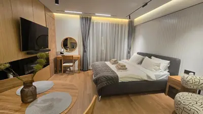 a bedroom with a bed and a living room at Genex SPA in Belgrade
