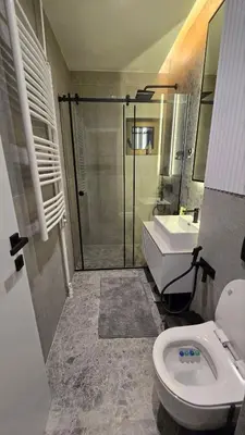 a bathroom with a shower and a toilet and a sink at Genex SPA in Belgrade