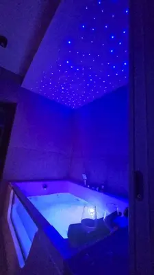 a purple room with a tub with a star ceiling at Genex SPA in Belgrade