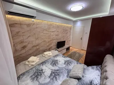 a small room with a bed and a television at Aktiva Apartments in Belgrade