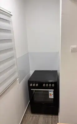 a black stove in a corner of a kitchen at Aktiva Apartments in Belgrade