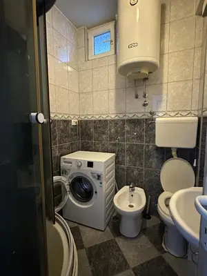 a small bathroom with a washing machine and a toilet at Apartment Ruby in Belgrade