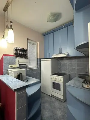 a kitchen with blue cabinets and a white refrigerator at Apartment Ruby in Belgrade