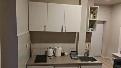 a kitchen with white cabinets and a counter top at AG Cozy Apartment in Belgrade
