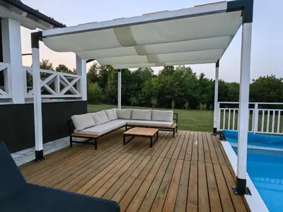 a pavilion with a couch and a table on a deck at Moje srećno mesto in Arandjelovac