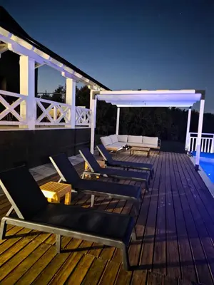 a deck with chaise lounges and a table at Moje srećno mesto in Arandjelovac