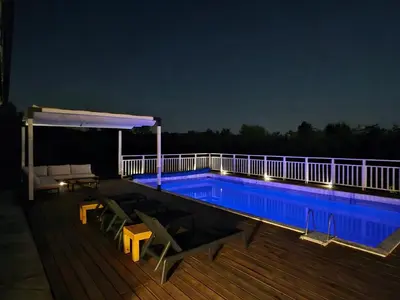 a swimming pool on a deck at night at Moje srećno mesto in Arandjelovac