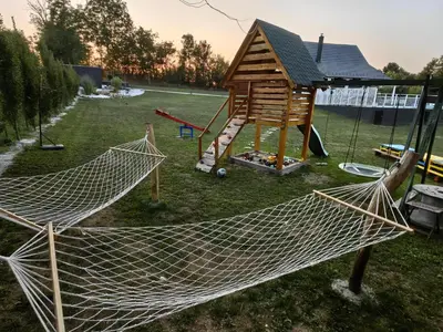 a hammock in a yard with a playground at Moje srećno mesto in Arandjelovac