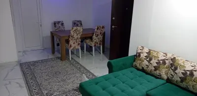 a living room with a green couch and a table at Melvina in Pančevo