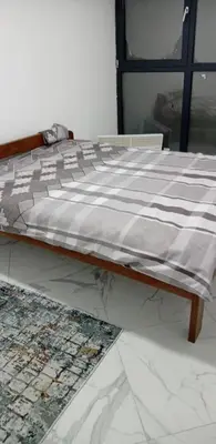a bed with a black and white comforter on it at Melvina in Pančevo