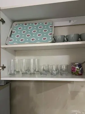 a kitchen shelf with bowls and glasses on it at Melvina in Pančevo