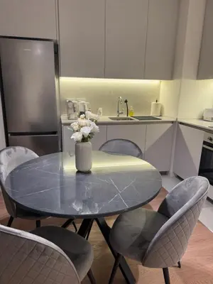 a kitchen with a table with a vase of flowers on it at Dockside Belgrade Waterfront in Belgrade
