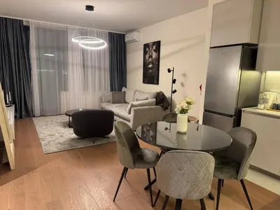 a living room with a table and chairs and a couch at Dockside Belgrade Waterfront in Belgrade