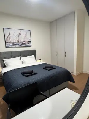 a bedroom with a bed with two black towels on it at Dockside Belgrade Waterfront in Belgrade