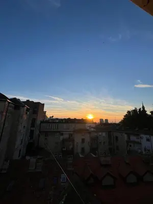 a sunset over a city with buildings and roofs at Pevac, Rooster, apartment in Belgrade