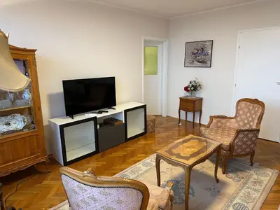a living room with a flat screen tv and chairs at Kalenić Sky in Belgrade