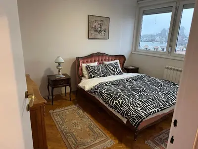 a bedroom with a zebra print bed with a window at Kalenić Sky in Belgrade