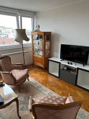 a living room with a tv and a couch and a chair at Kalenić Sky in Belgrade