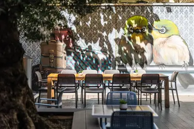 a table and chairs in front of a wall with a painting at Nobel Palace Hotel in Belgrade