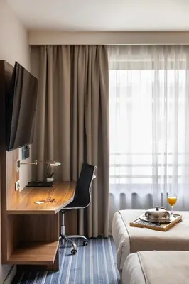 a hotel room with a desk and a bed at Nobel Palace Hotel in Belgrade