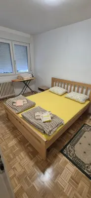 a bedroom with two beds in a room with two windows at Two Sister in Belgrade