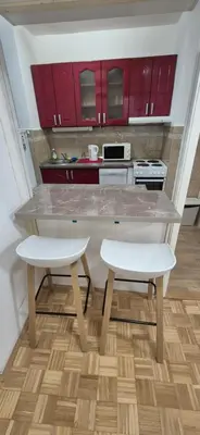 a kitchen with red cabinets and a marble counter top at Two Sister in Belgrade