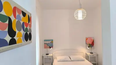 a white bedroom with a bed and a painting at Center 1 Queen bed Sofa Additional living area in Belgrade