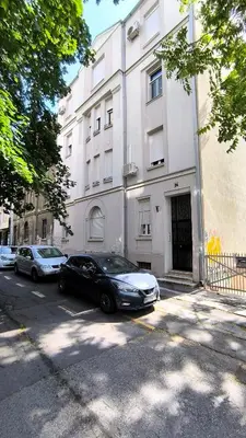 a black car parked in front of a white building at Center 1 Queen bed Sofa Additional living area in Belgrade