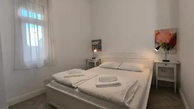 a bedroom with a white bed with towels on it at Center 1 Queen bed Sofa Additional living area in Belgrade