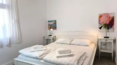 a white bedroom with two towels on a bed at Center 1 Queen bed Sofa Additional living area in Belgrade