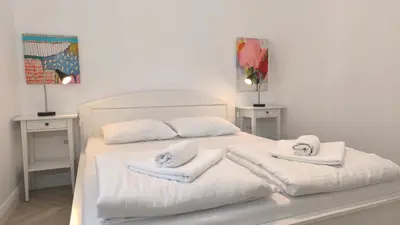 a bedroom with a white bed with towels on it at Center 1 Queen bed Sofa Additional living area in Belgrade