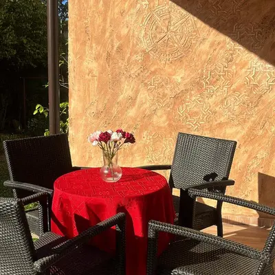 a red table with a vase of flowers on it at Stan ARS in Belgrade